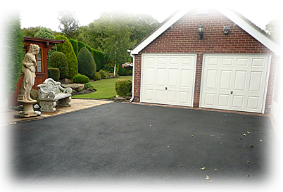 a photo of an asphalt driveway leading to a garage